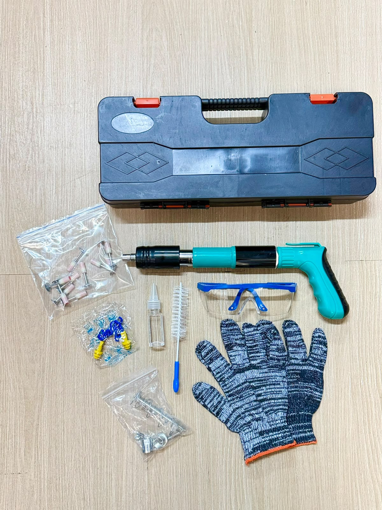 Kit de la herramienta con maletín, guantes, gafas, cepillo y bolsas de piezas sobre una mesa.
