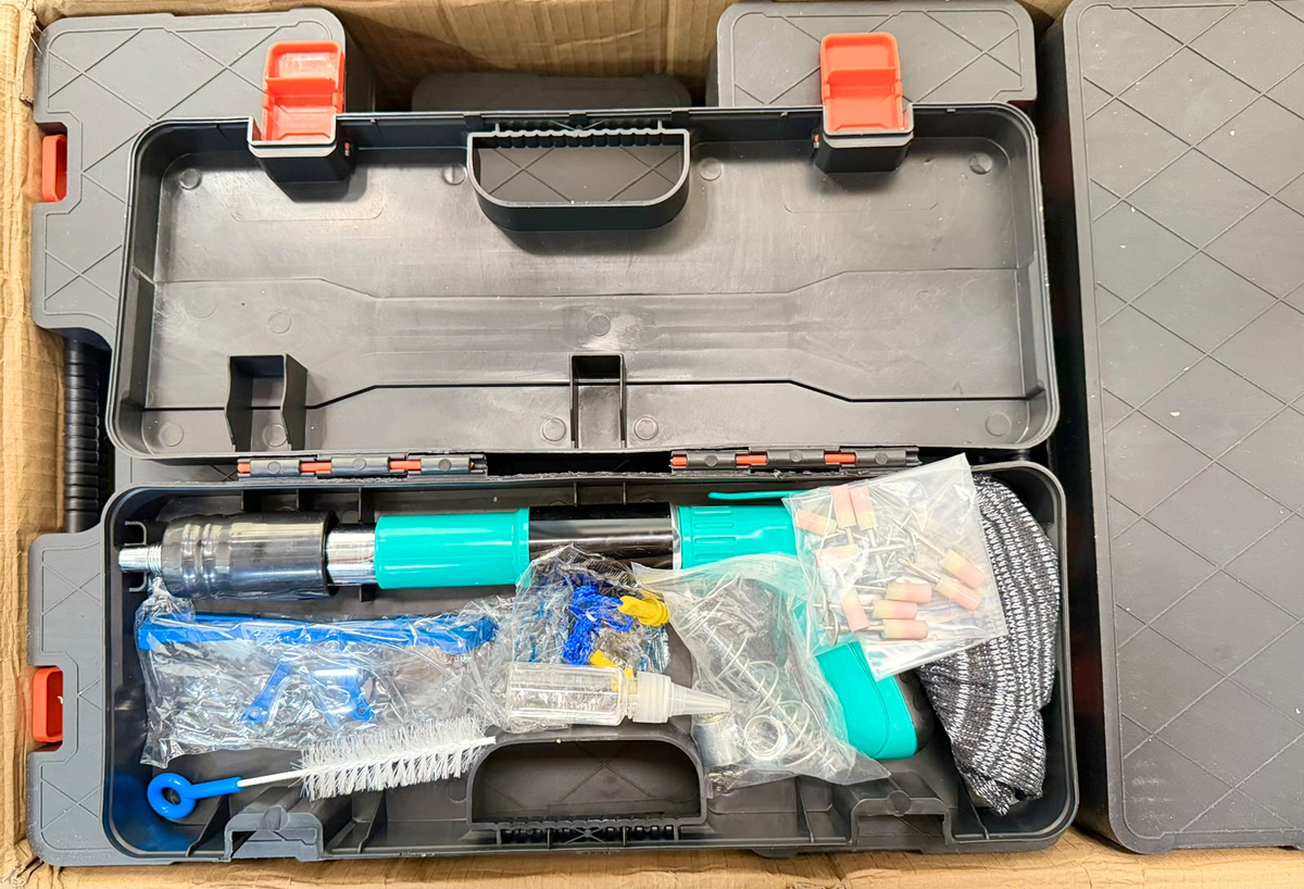 Herramienta de fijación turquesa y negra dentro del maletín abierto con accesorios.
