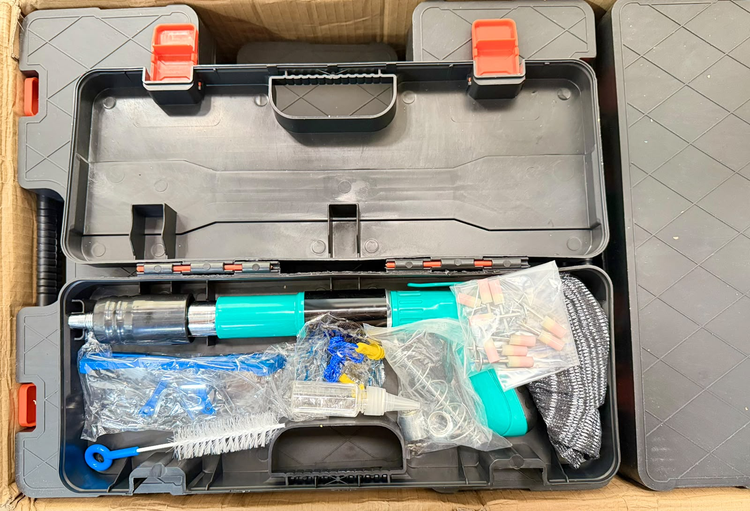 Herramienta de fijación turquesa y negra dentro del maletín abierto con accesorios.